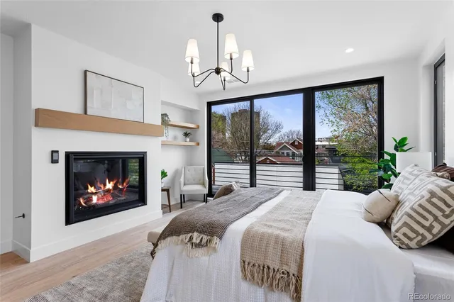 a bedroom with a bed large window and fireplace