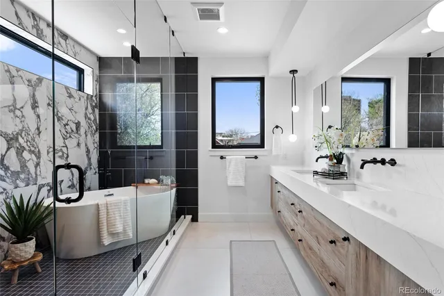 a bathroom with a double vanity sink a large mirror a bathtub and a shower