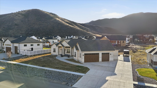 534 East Fish Hatchery Road Mantua, UT 84324 - Photo 73 of 87 View of front of property featuring a garage, a residential view, concrete driveway, stone siding, and a mountain view
