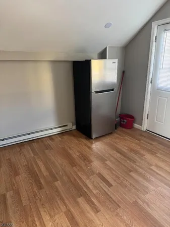 a view of empty room with wooden floor and cabinet