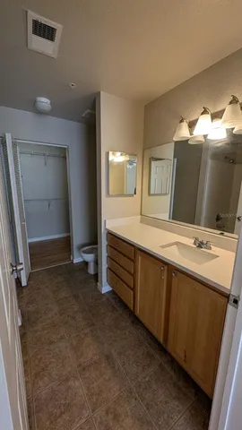 an empty room with wooden floor and fan