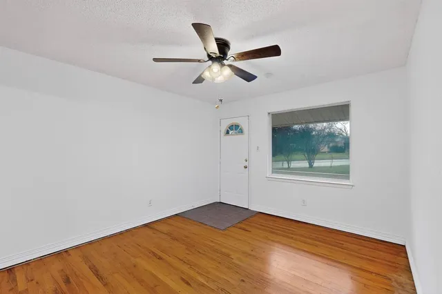 a view of an empty room with a window and a ceiling fan