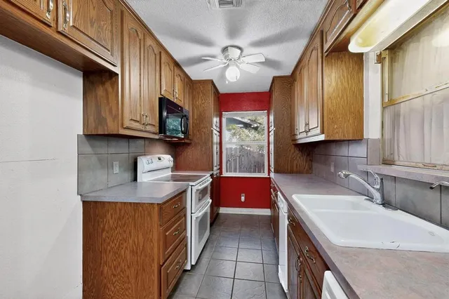 a kitchen with stainless steel appliances granite countertop a sink stove and cabinets