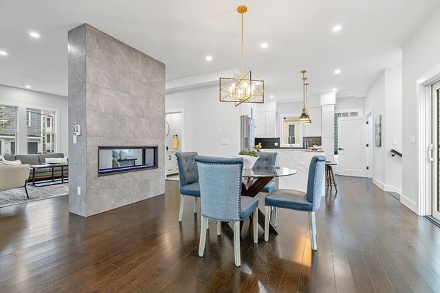 a view of a a dining room with furniture wooden floor and a chandelier