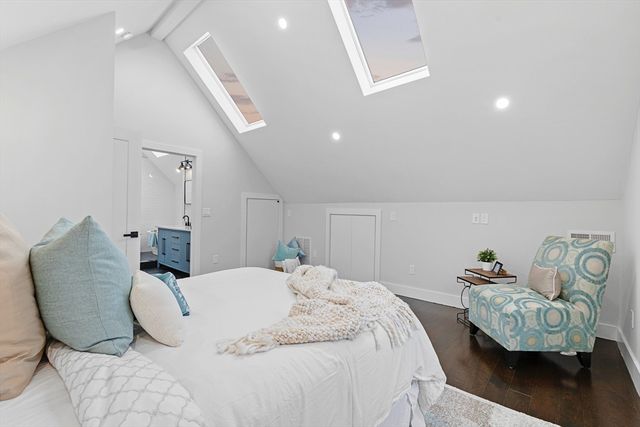 a large bedroom with a bed and wooden floor