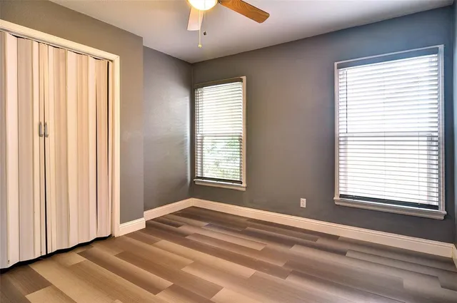 a view of an empty room with a window and a ceiling fan