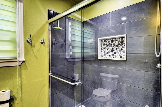 a bathroom with a toilet and a shower