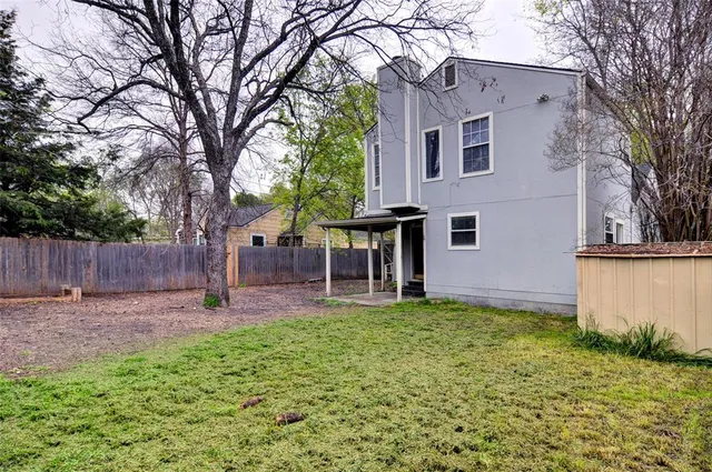 a front view of a house with a yard and trees