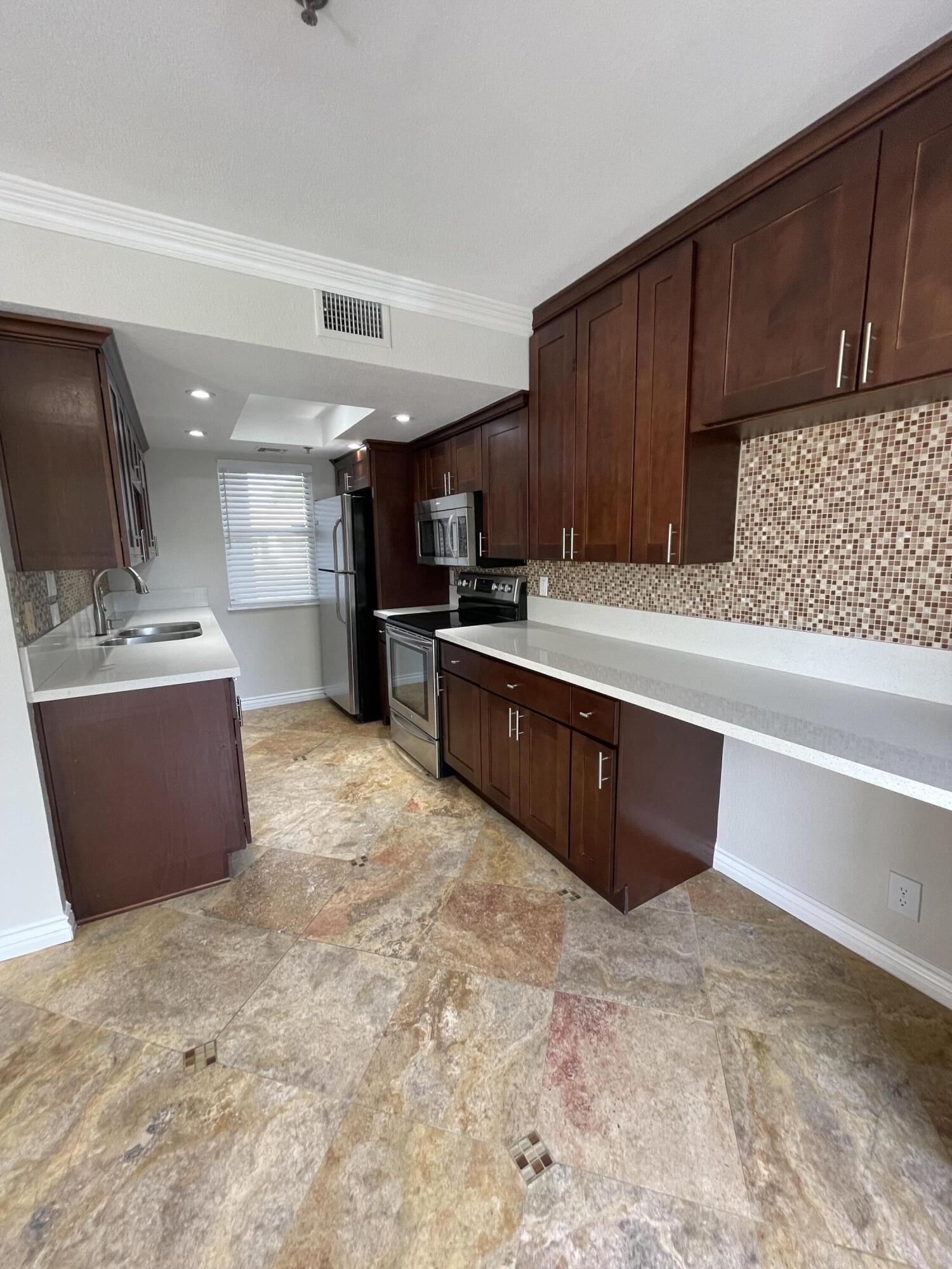 43376 Cook Street, Unit 52 Palm Desert, CA 92211 - Photo 3 of 42 a large kitchen with stainless steel appliances granite countertop a sink and cabinets