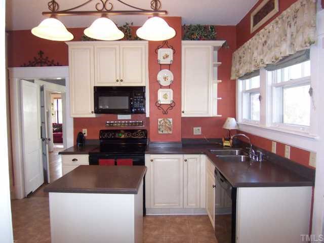 519 Gardner Street Raleigh, NC 27607 - Photo 8 of 12 a kitchen with a stove a sink and a refrigerator