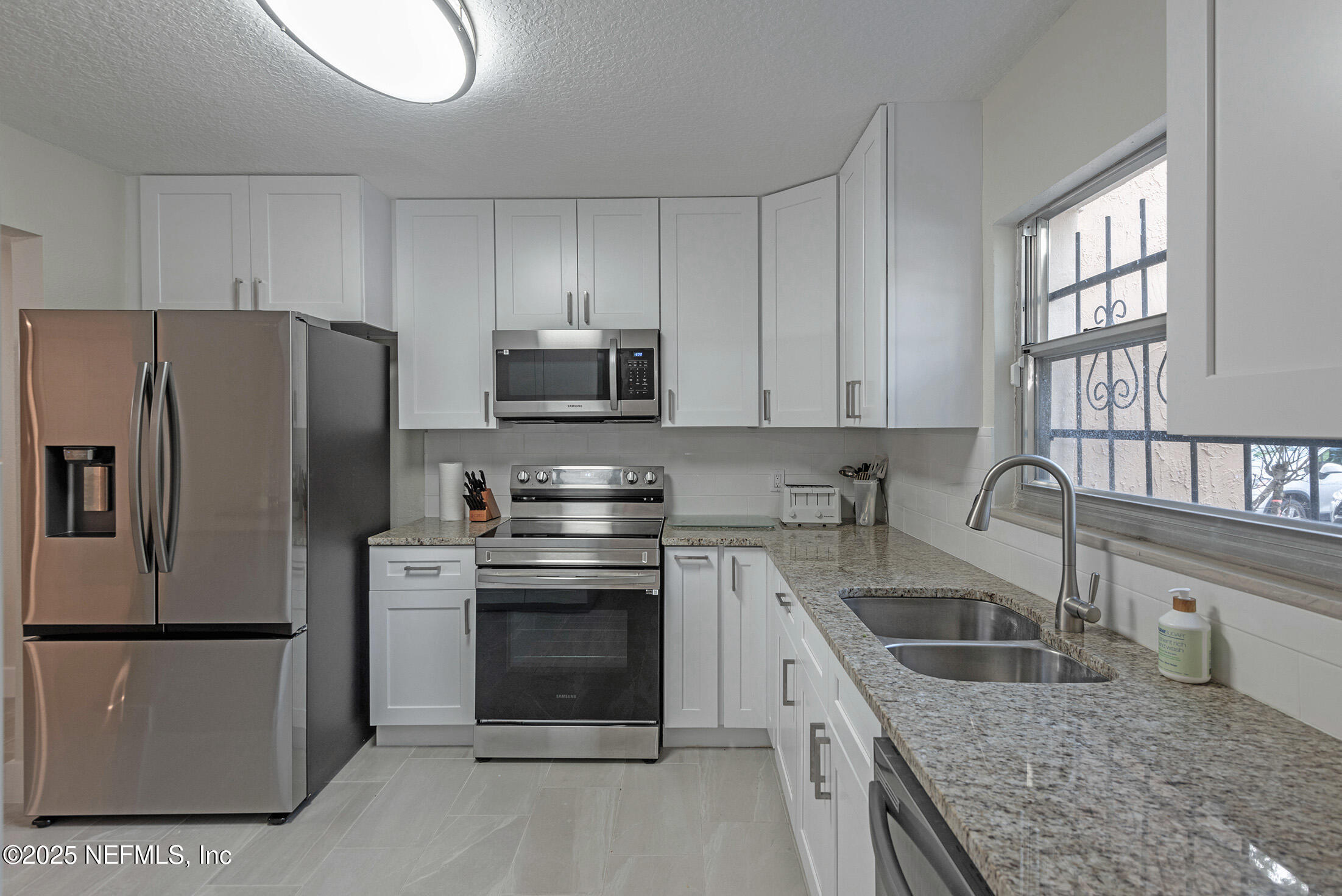 346 Raleigh Road, Unit 346 Jacksonville, FL 32225 - Photo 8 of 43 a kitchen with stainless steel appliances granite countertop a sink stove microwave and refrigerator