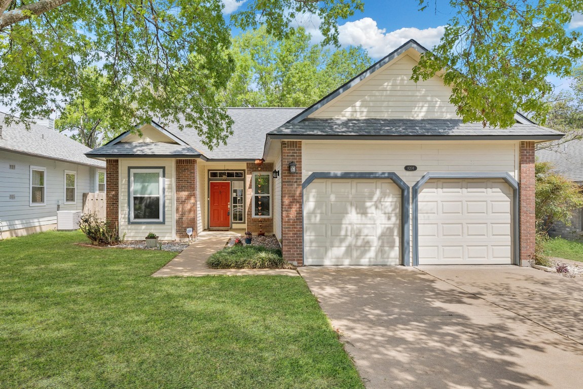 8208 Foxhound Trail Austin, TX 78729 - Photo 1 of 1 a front view of a house with a garden and yard