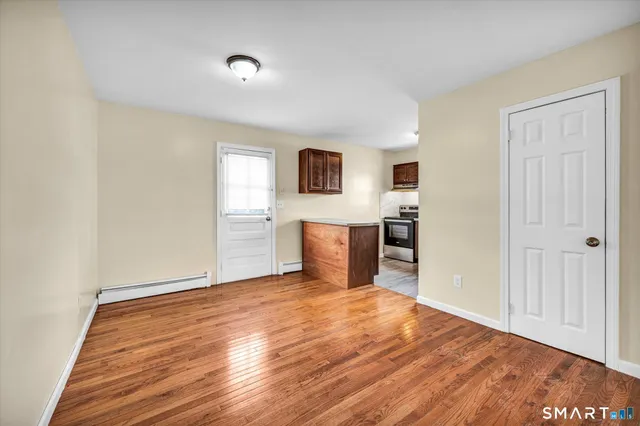 a view of a kitchen with wooden floor and a ceiling fan