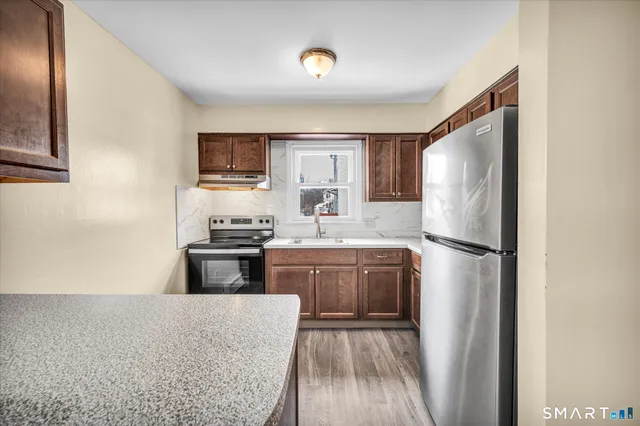 a kitchen with stainless steel appliances granite countertop a refrigerator sink and stove