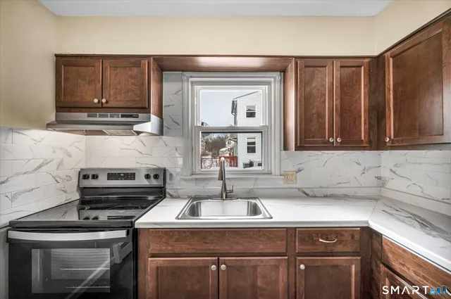 a kitchen with a sink cabinets and stainless steel appliances