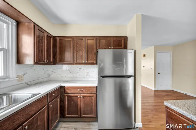 a kitchen with a refrigerator sink and cabinets