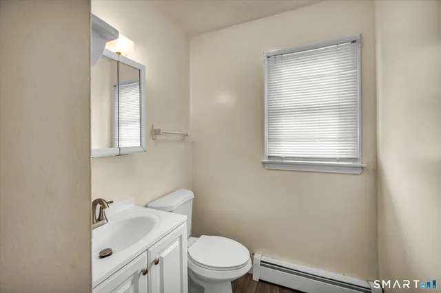 a bathroom with a sink a toilet and a window