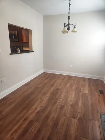 a view of a room with wooden floor and chandelier