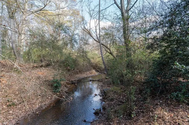 a view of a house with backyard and trees