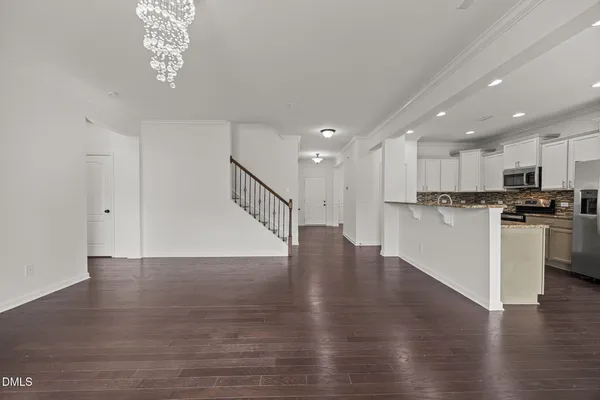 an empty room with wooden floor fireplace and windows