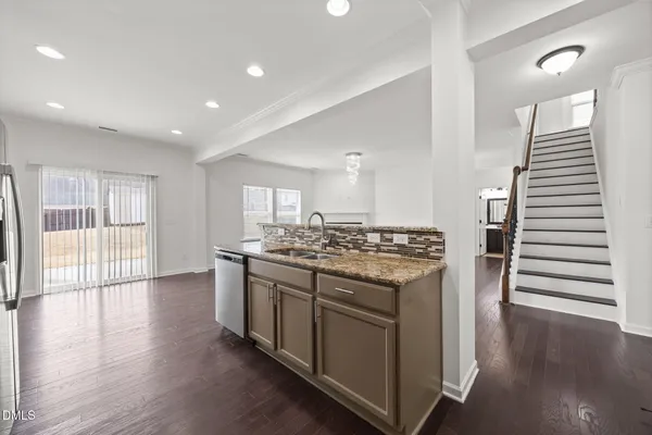 a kitchen with stainless steel appliances white cabinets and a stove a refrigerator with wooden floor