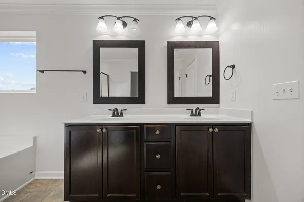 a spacious bathroom with double vanity two mirror and a bathtub