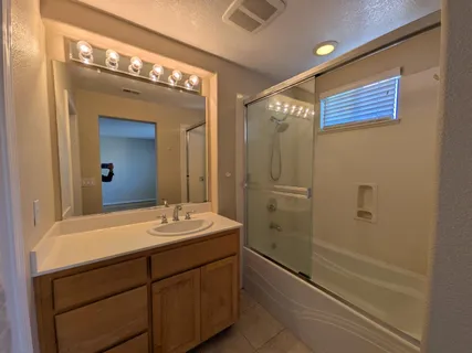 a bathroom with a double vanity sink mirror and shower