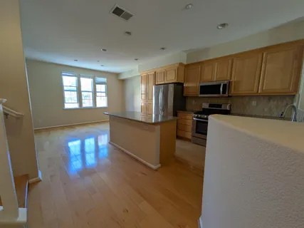 a kitchen with stainless steel appliances a refrigerator a stove top oven a sink and dishwasher