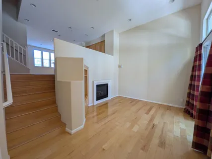 a view of an empty room with a windows and wooden floor