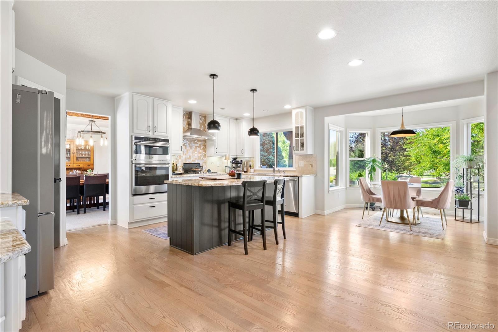 3822 Broadmoor Loop Broomfield, CO 80023 - Photo 21 of 50 a room with stainless steel appliances a dining table wooden floor and a view of kitchen