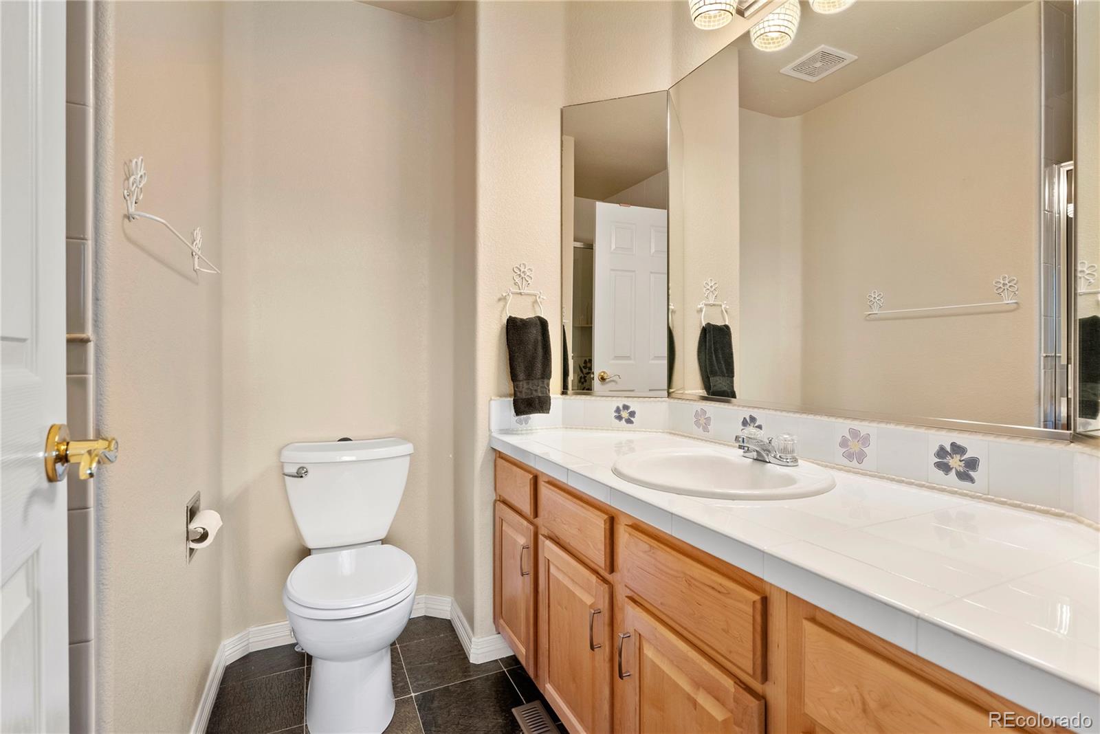 3822 Broadmoor Loop Broomfield, CO 80023 - Photo 34 of 50 a bathroom with a toilet sink and mirror