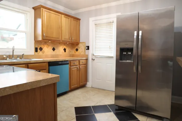 a kitchen with stainless steel appliances granite countertop a sink and a refrigerator