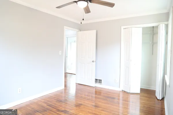 a view of an empty room with wooden floor