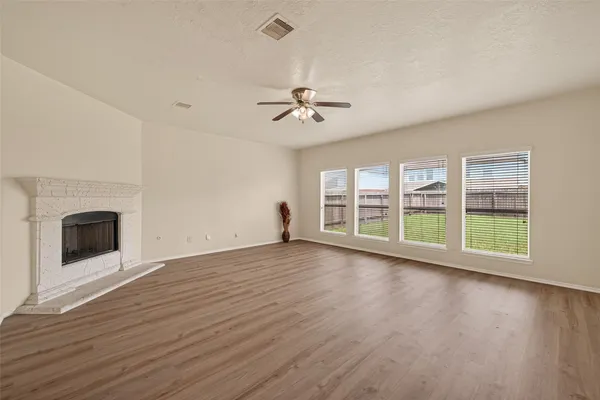a view of empty room with wooden floor and a fireplace
