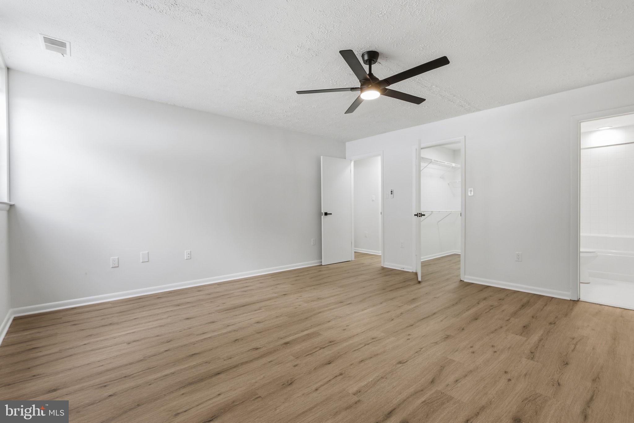 2201 Woodbox Lane, Unit 2201A Baltimore, MD 21209 - Photo 12 of 21 a view of empty room with wooden floor and ceiling fan