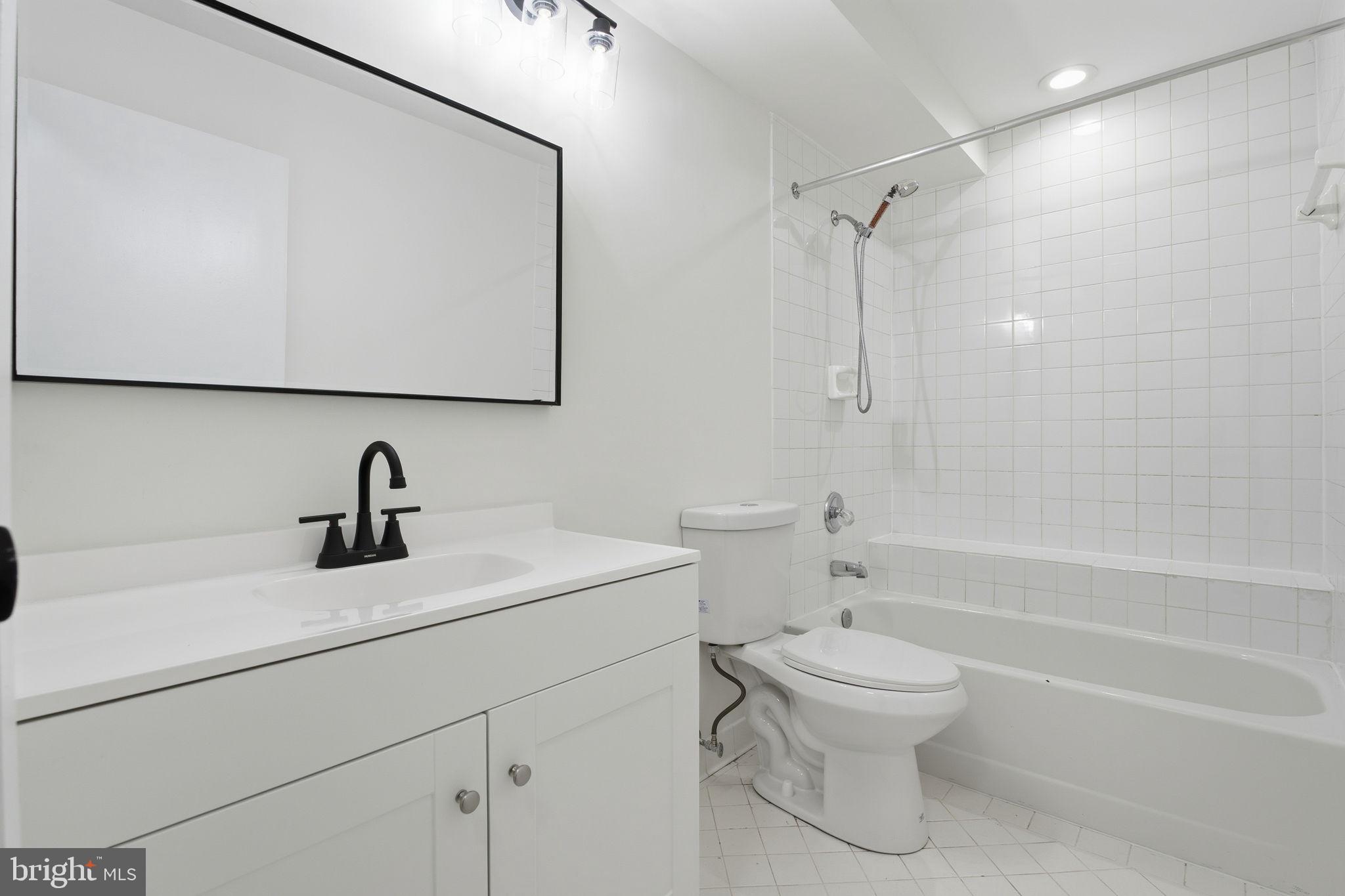 2201 Woodbox Lane, Unit 2201A Baltimore, MD 21209 - Photo 18 of 21 a bathroom with a sink a toilet and a bathtub