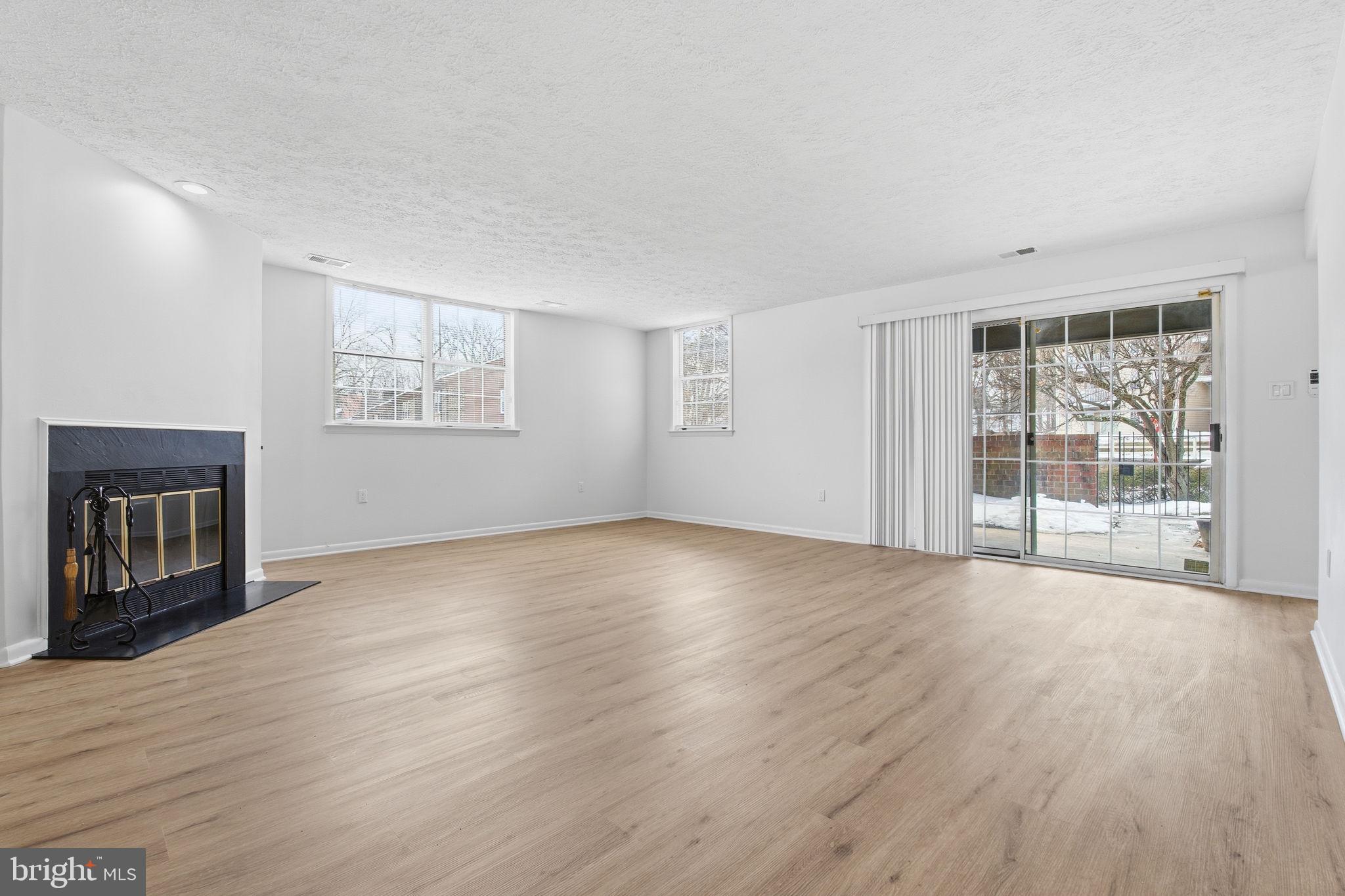 2201 Woodbox Lane, Unit 2201A Baltimore, MD 21209 - Photo 6 of 21 a view of an empty room with wooden floor and a window