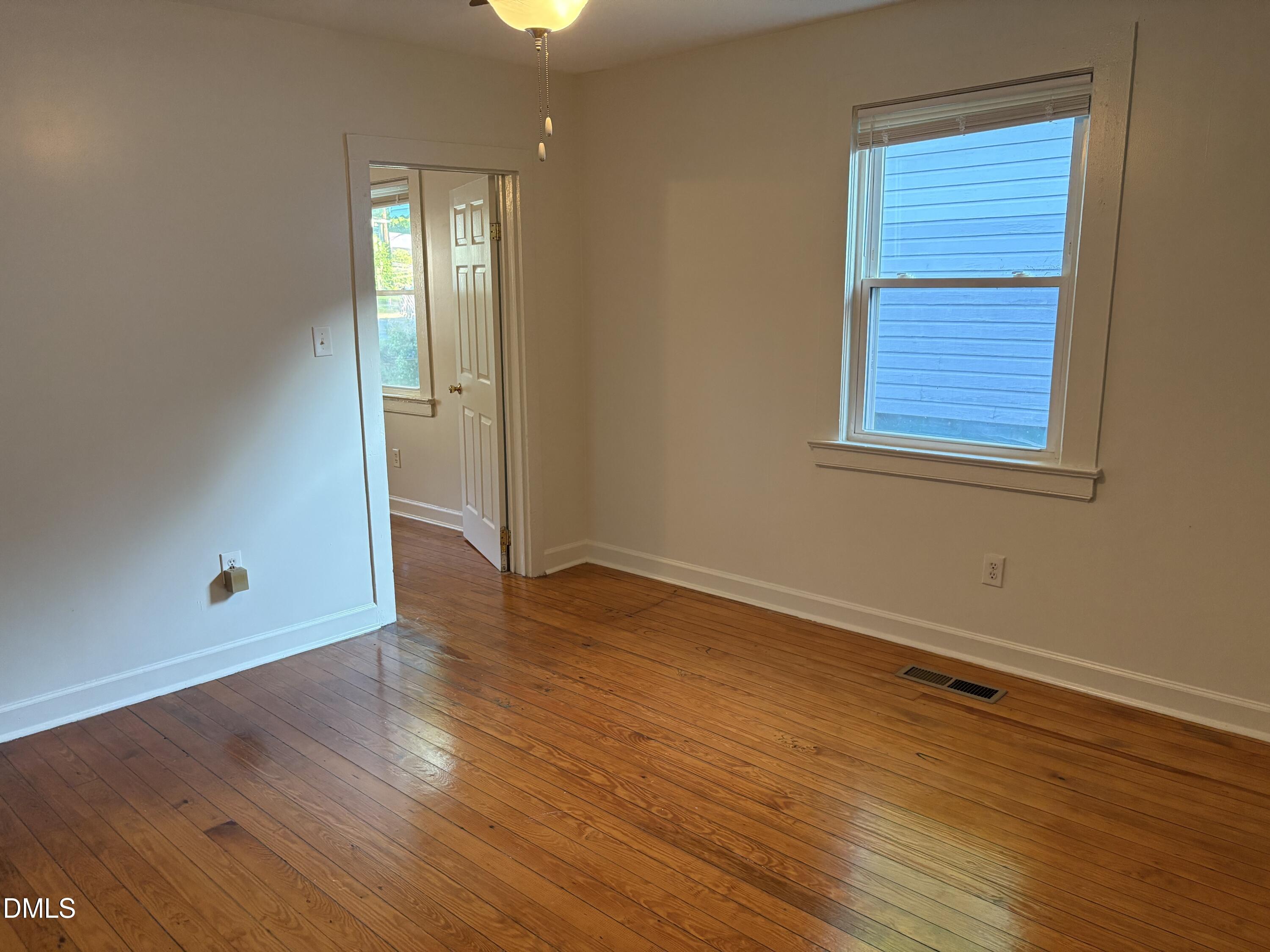 1020 Sedgefield Street Durham, NC 27705 - Photo 4 of 21 an empty room with wooden floor and windows