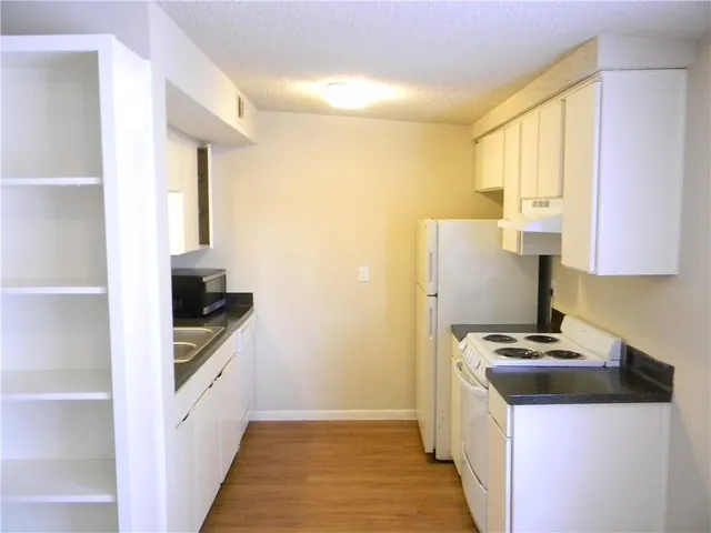 a kitchen with granite countertop a sink and a stove top oven