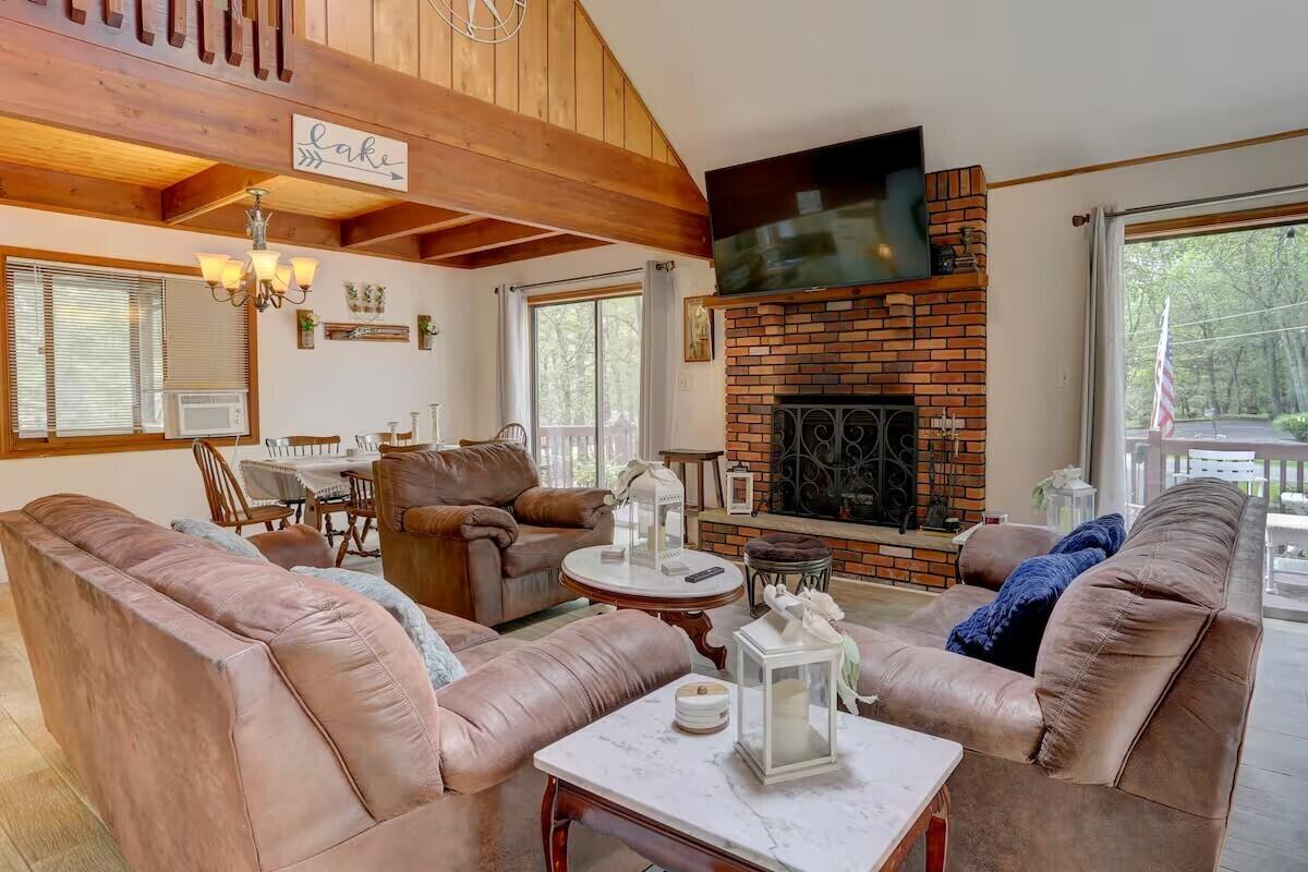 2255 Scarborough Way Bushkill, PA 18324 - Photo 4 of 24 a living room with furniture a fireplace a flat screen tv and windows