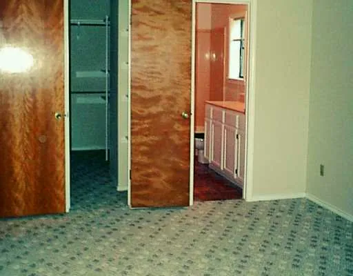 an empty room with an entrance to other room
