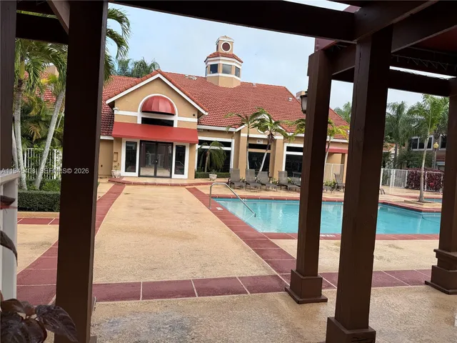 a view of a building with a floor to ceiling window and a tree