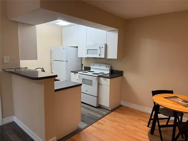 a kitchen with a refrigerator and a stove top oven