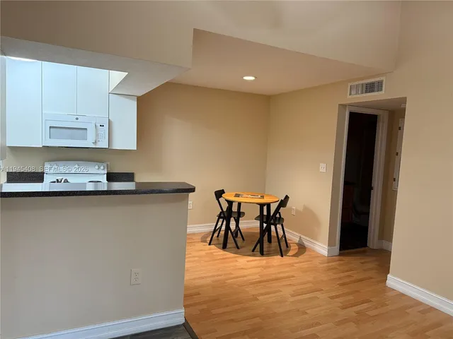 a view of kitchen with cabinets and wooden floor