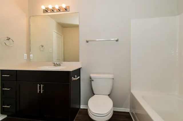 a bathroom with a sink a toilet a mirror and shower