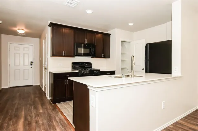 a kitchen with stainless steel appliances a stove microwave and refrigerator