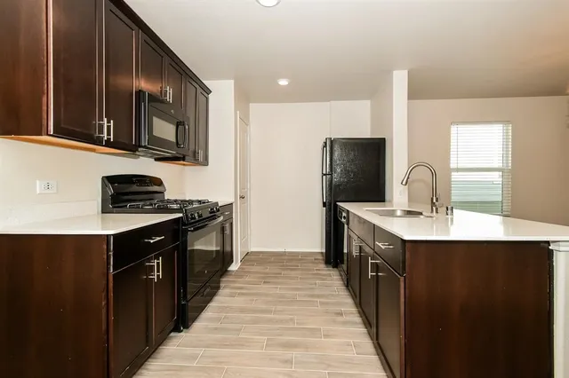 a kitchen with stainless steel appliances a sink stove top oven and cabinets