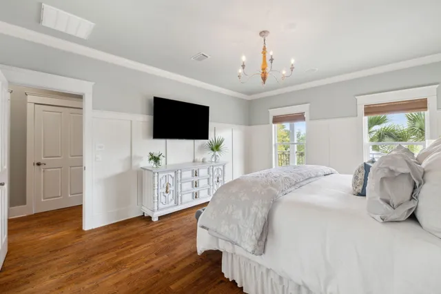 a spacious bedroom with a bed and a flat screen tv