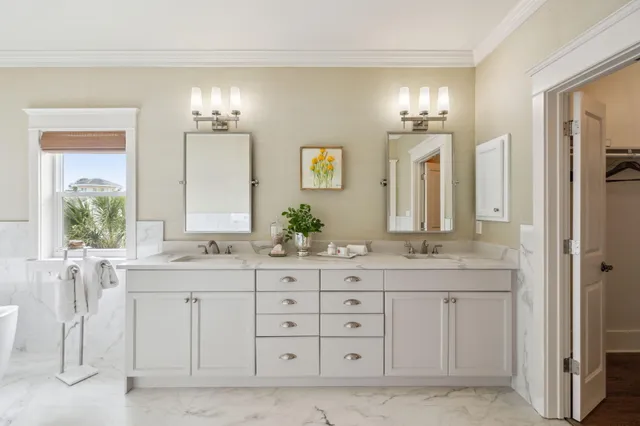 a spacious bathroom with double sink a mirror a window and a