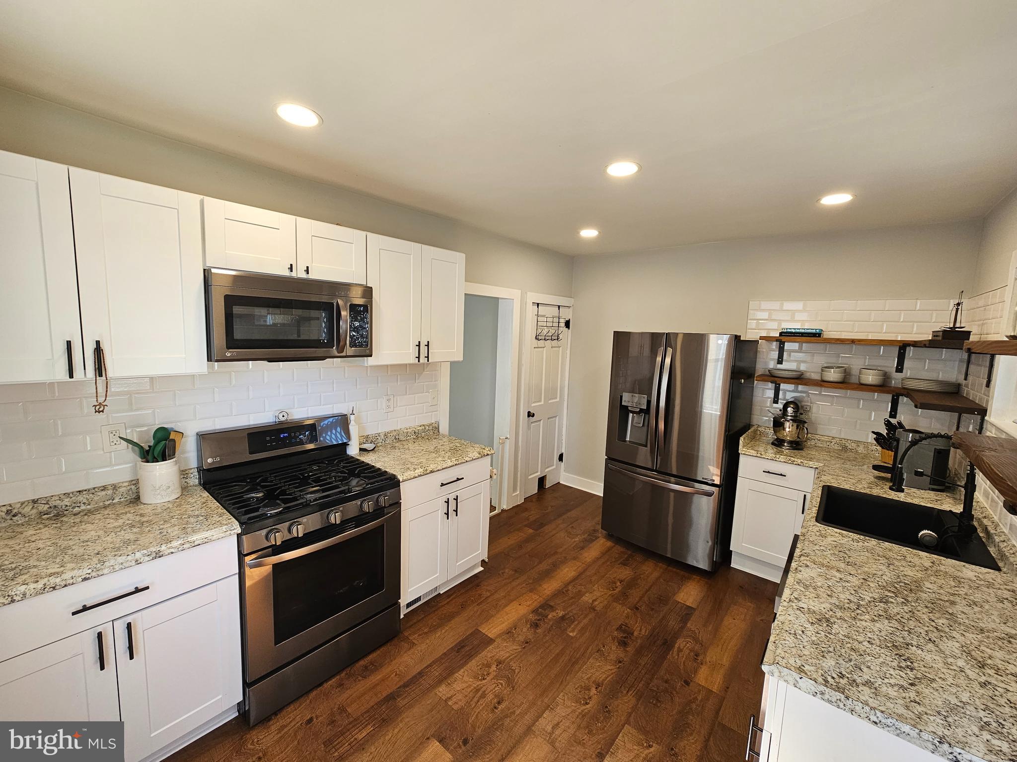 303 Delaware Avenue Riverside, NJ 08075 - Photo 6 of 30 a kitchen with refrigerator a microwave a sink and cabinets